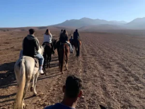 A group enjoying horse riding in the Atlas Mountains near Marrakech, exploring scenic desert trails with mountains in the background.