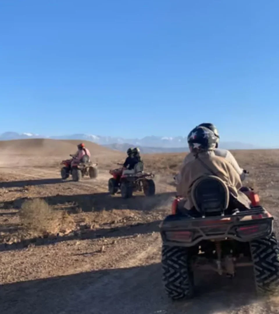 Group riding on the best Agafay Desert quad bike ride, kicking up dust as they explore the rugged desert landscape.