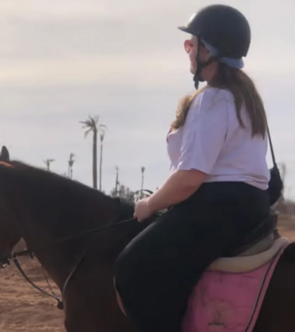 A rider enjoying horse riding in Marrakech Morocco, exploring desert landscapes with palm trees in the background.